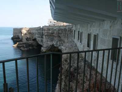Scendiamo e ci ritroviamo su una terrazzina pi� bassa ma ancora pi� suggestiva: da qui � quasi possibile toccare la robusta scogliera che si apre in tre pittoresche grotte